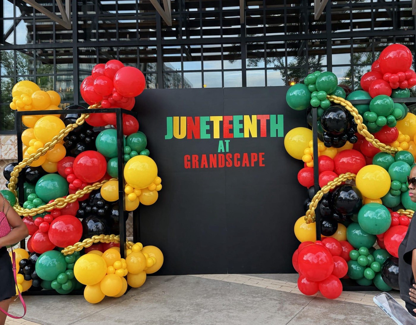 Juneteenth at Grandscape balloon arch installation in red, yellow, green and black